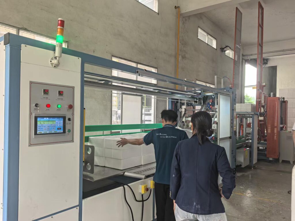 YouXin engineer and Jiabao Vietnam staff reviewing EPS wrapping machine operation in the plant